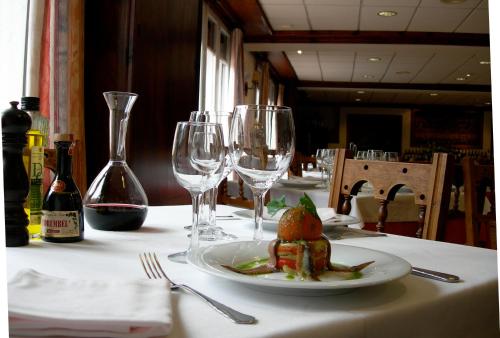 a table with a plate of food and wine glasses at Hosteria Catalana in Bossost