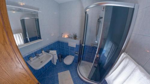 a bathroom with a shower and a toilet and a sink at White Stone Villa 43 in Promajna