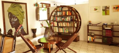 una habitación con una mesa y una estantería con libros en Gites Rose des Vents en Deshaies