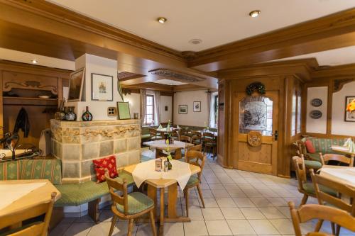 a restaurant with tables and chairs and a fireplace at Hotel Löwen in Randersacker