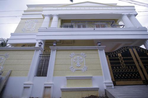 a white building with a balcony and a gate at Iris Comfort Inn in Chennai