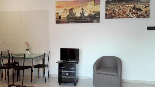 a dining room with a table and a chair and a television at Beva Fiera Bologna in Bologna