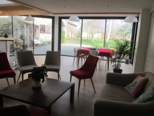 a living room with a couch and tables and chairs at La Petite Charnasserie in Angers