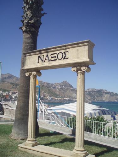 a sign that says nazoco next to a palm tree at B&B Al Sole di Sicilia in Giardini Naxos