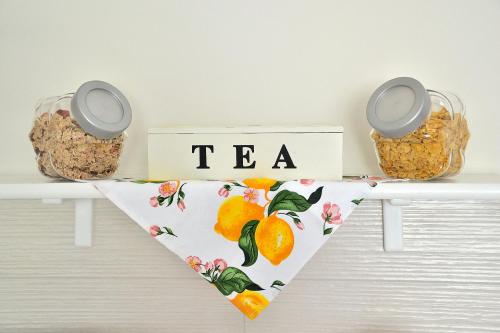 a table with a tea sign and two baskets of oranges at B&B Al Sole di Sicilia in Giardini Naxos