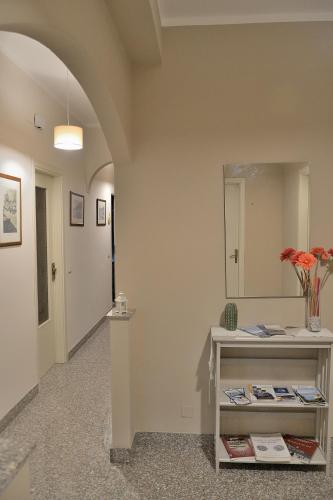 a hallway with a mirror and a table with books at B&B Al Sole di Sicilia in Giardini Naxos