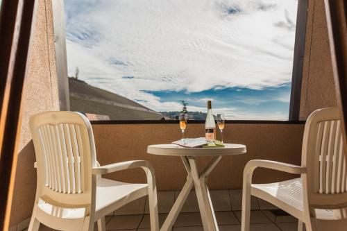a table with two chairs and a bottle of wine at Hotel Löwen in Randersacker