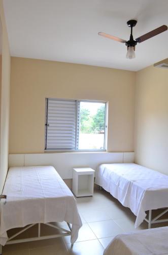a bedroom with two beds and a window at Condomínio Recanto dos Dourados - Casa de Temporada in Três Marias