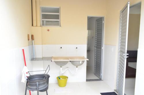 a kitchen with a sink and chairs in a room at Condomínio Recanto dos Dourados - Casa de Temporada in Três Marias