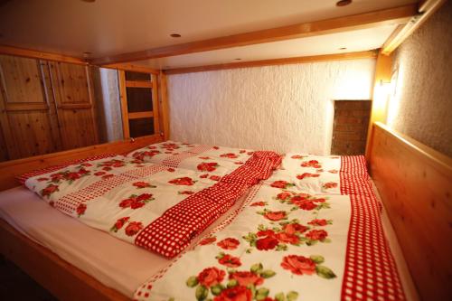 a bed in a room with red roses on it at Kesslerhütte in Schladming