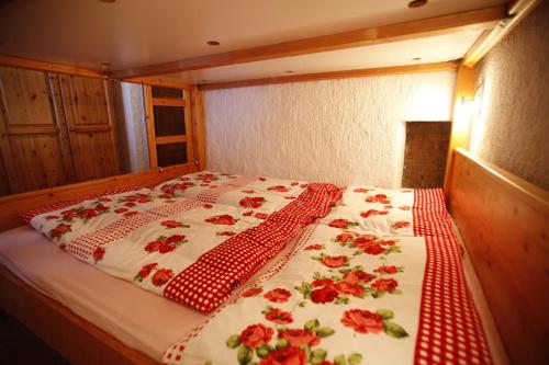 シュラートミンクにあるKesslerhütteの赤いバラが飾られた部屋のベッド1台