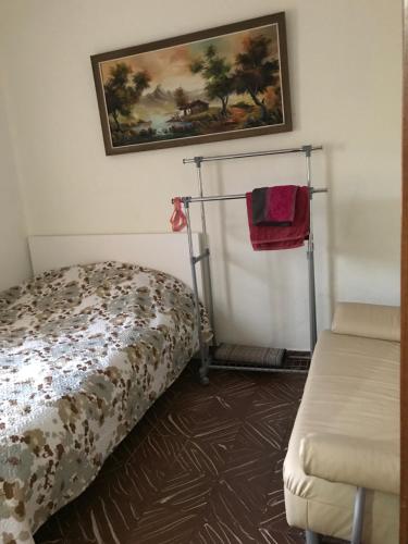 バレンシアにあるAlex Apartmentのベッドルーム1室(ベッド1台付)が備わります。壁には絵画が飾られています。