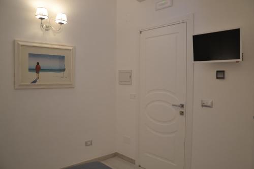 a white hallway with a door and a television at Cuore di Vieste in Vieste