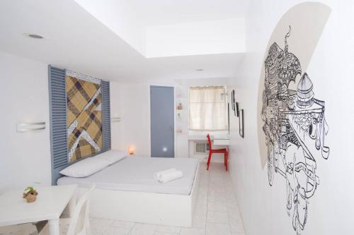 a white room with a bed and a surfboard on the wall at Frank Lloyd Apartelle in Manila