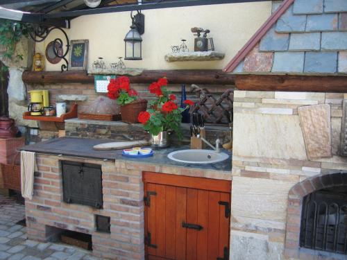 an outdoor kitchen with a sink and a fireplace at MaaRitza Holiday Cottage in Türi