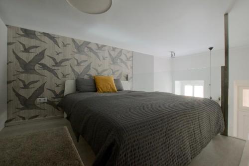 ブダペストにあるStandard Apartment by Hi5 - Teréz 6のベッドルーム1室(ベッド1台付)、壁に鳥が飾られています。