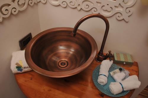a copper sink on a wooden counter with towels at Hotel Casa Ambrosia in Villeta
