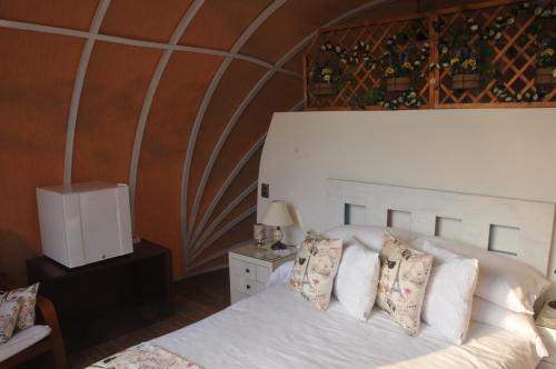 a bedroom with a bed with white sheets and pillows at Hotel Casa Ambrosia in Villeta