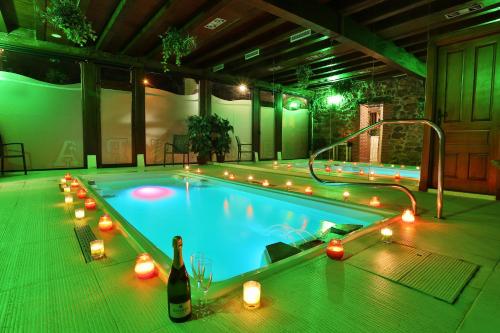a swimming pool with a bottle of wine and candle lights at Hotel Spa Casona La Hondonada in Terán