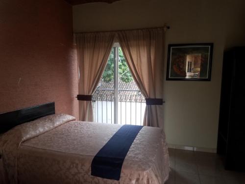 a bedroom with a bed and a large window at Hotel Gesa in Villa Corona