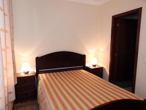ein Schlafzimmer mit einem Bett mit zwei Lampen an Tischen in der Unterkunft Aqui Jardim in Reguengos de Monsaraz
