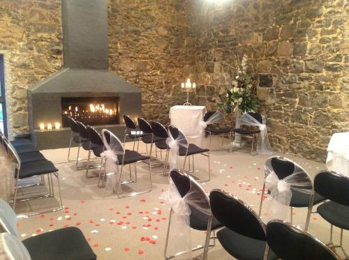 a room with chairs and a fireplace with flowers on the floor at Dunedin Leisure Lodge - Distinction in Dunedin