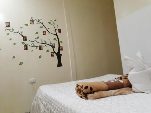 a bedroom with a tree with pictures on the wall at Villa Encantador Resort in San Vicente