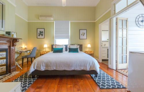 a bedroom with a bed with blue pillows and a desk at 99 Kirkland Bed & Breakfast in Brisbane