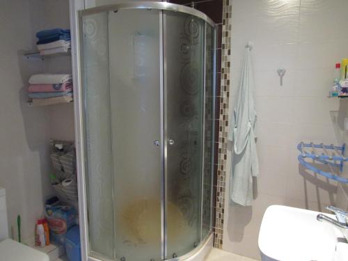 W łazience znajduje się prysznic ze szklanymi drzwiami. w obiekcie Apartment Essayadi Residence w mieście Port El Kantaoui