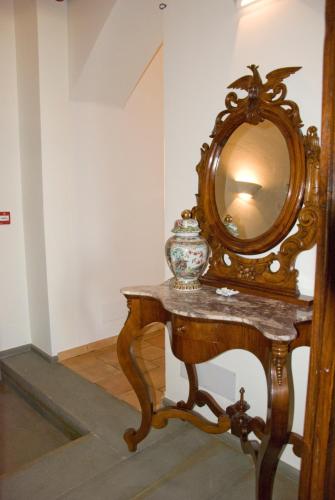 a mirror on a table with a vase on it at San Francesco Resort in Agropoli