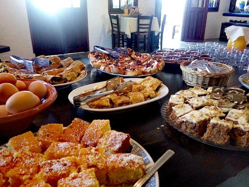 a table full of different types of food on plates at Vagia Beach Apartments, Aegina Island in Vaia