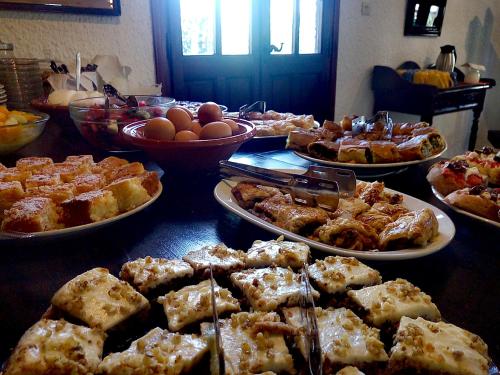 a table with many plates of food on it at Vagia Beach Apartments, Aegina Island in Vaia