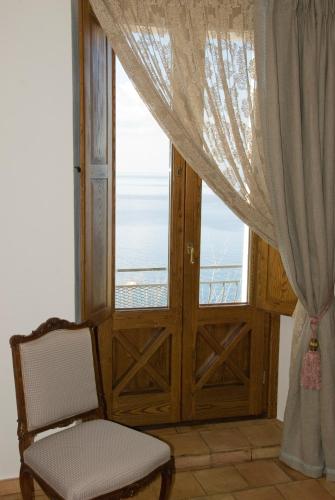 a room with a door and a chair and a window at San Francesco Resort in Agropoli