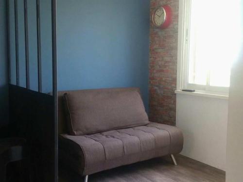 a couch in a room with a clock on the wall at Departamento Central in Arica