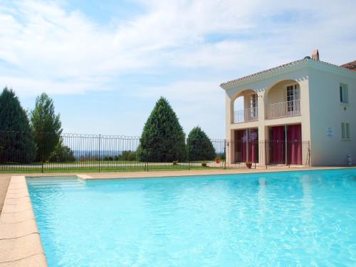 a swimming pool in front of a house at La Ginelle - Appartement Bocage in Airoux