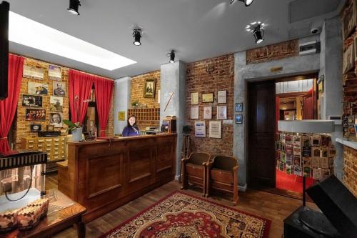 a woman standing at a bar in a room at Stare Kino Cinema Residence in Łódź