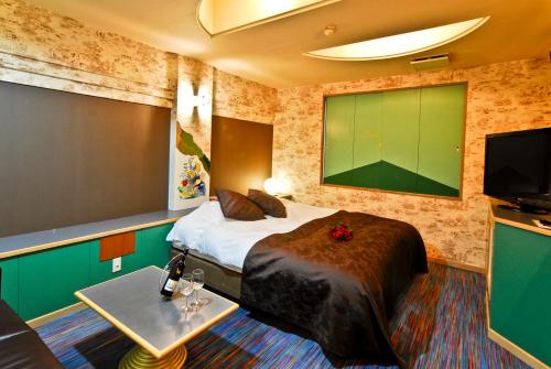 a hotel room with a bed and a flat screen tv at Hotel Joy (Love Hotel) in Onga