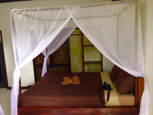 a bed with a canopy in a room at Rock Pool Homestay in Huu