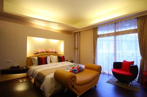 花蓮市的住宿－看見鐵道民宿，酒店客房设有一张大床和一张红色椅子。