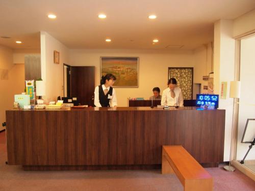 two women are standing at a reception desk at Hotel Innoshima in Onomichi