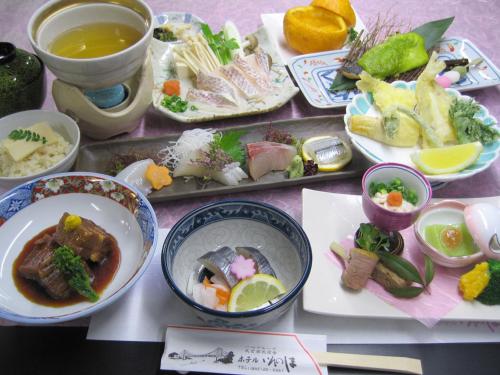 a table with plates of food and bowls of food at Hotel Innoshima in Onomichi