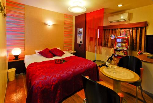 Habitación de hotel con cama, mesa y mesa. en Hotel Joyseaside (Love Hotel) en Munakata