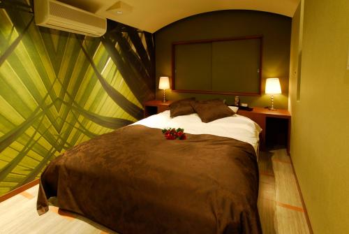 - une chambre avec un grand lit fleuri dans l'établissement Hotel Yarma (Adult Only), à Shimonoseki