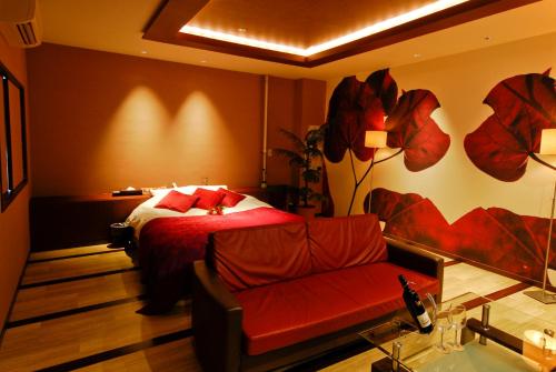 une chambre avec un lit, une chaise et un miroir dans l'établissement Hotel Yarma (Adult Only), à Shimonoseki