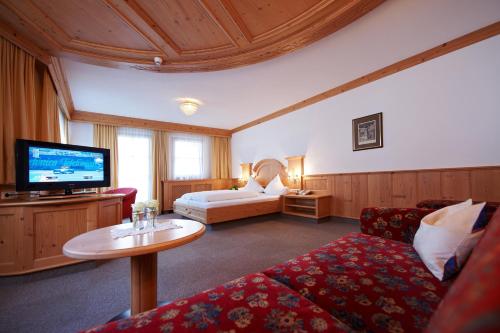 a hotel room with a couch and a tv at Höllboden in Ischgl