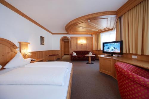 ein Hotelzimmer mit einem Bett und einem Flachbild-TV in der Unterkunft Höllboden in Ischgl