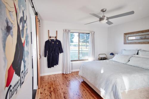 a white bedroom with a bed and a window at Moodemere Lake House in Rutherglen