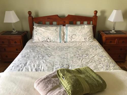 Armadale House - Kingscote في كنغزكوت: غرفة نوم مع سرير مع مواقف ليلتين