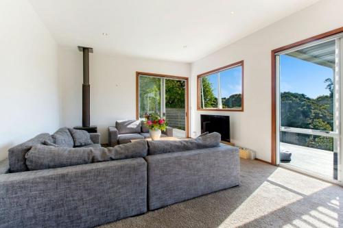 a living room with two couches and a large window at Karaka Sanctuary with Spa Pool by Waiheke Unlimited in Oneroa