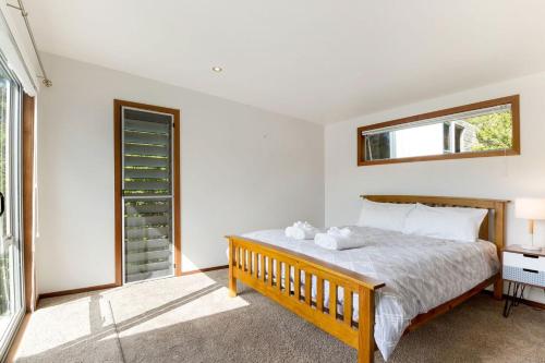 a bedroom with a bed and a window at Karaka Sanctuary with Spa Pool by Waiheke Unlimited in Oneroa